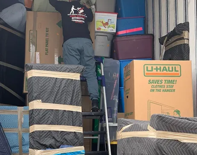 A man on a ladder in a moving truck. Storage Services Household Moving